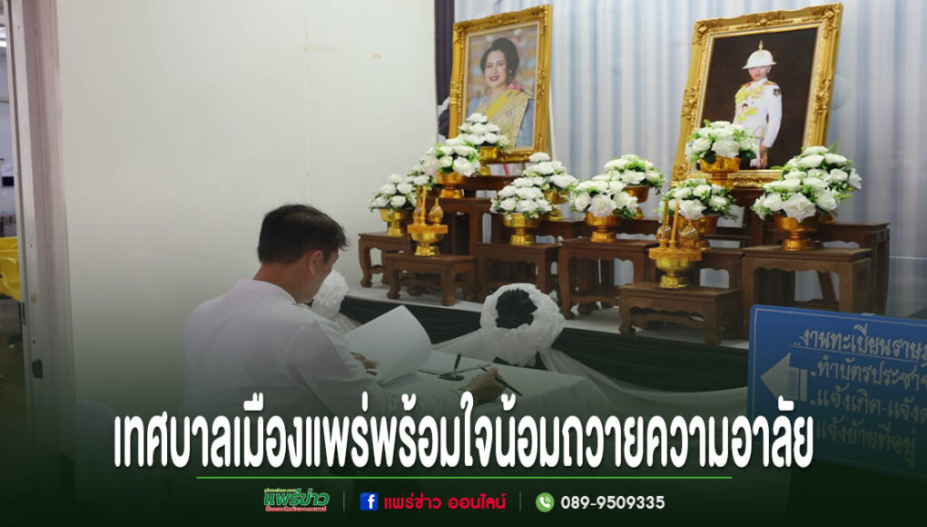 ชายสวมเสื้อขาวนั่งลงนามถวายความอาลัยหน้าโต๊ะหมู่บูชาที่มีพระบรมฉายาลักษณ์และพานพุ่มดอกไม้สีขาว