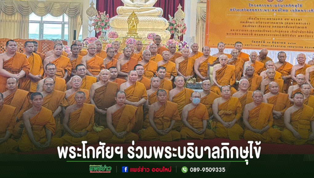 กลุ่มพระสงฆ์ในจีวรสีส้มร่วมถ่ายภาพหมู่หน้าพระพุทธรูป