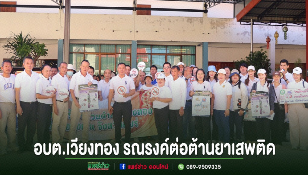 กลุ่มคนร่วมกิจกรรมรณรงค์ต่อต้านยาเสพติดของ อบต.เวียงทอง ยืนเรียงแถวถือป้ายประชาสัมพันธ์