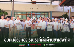 กลุ่มคนร่วมกิจกรรมรณรงค์ต่อต้านยาเสพติดของ อบต.เวียงทอง ยืนเรียงแถวถือป้ายประชาสัมพันธ์