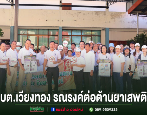 กลุ่มคนร่วมกิจกรรมรณรงค์ต่อต้านยาเสพติดของ อบต.เวียงทอง ยืนเรียงแถวถือป้ายประชาสัมพันธ์