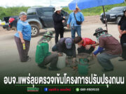 กลุ่มคนกำลังตรวจงานบนถนนลูกรัง ข้างรถกระบะ พร้อมข้อความ อบจ.แพร่ลุยตรวจเข้มโครงการปรับปรุงถนน