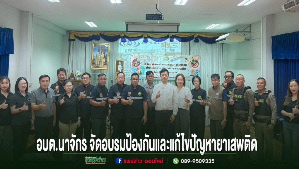 ff กลุ่มคนยืนเรียงแถวถ่ายรูปหมู่ในห้องประชุม มีป้ายข้อความภาษาไทยด้านล่างภาพ