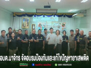 องค์การบริหารส่วนตำบลนาจักร เปิดโครงการอบรมป้องกันและแก้ไขปัญหายาเสพติด ประจำปีงบประมาณ พ.ศ. 2569 กลุ่มคนยืนเรียงแถวถ่ายรูปหมู่ในห้องประชุม มีป้ายข้อความภาษาไทยด้านล่างภาพ