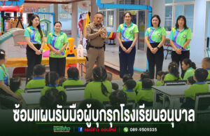 อบต.ร่องกาศ ซ้อมแผนรับมือผู้บุกรุกโรงเรียนอนุบาล บูรณาการตำรวจ-ครู เสริมความปลอดภัยให้นักเรียน ตำรวจและครูกำลังบรรยายให้ความรู้แก่เด็กนักเรียนอนุบาลที่นั่งฟังอยู่บนเก้าอี้และบนพื้นห้องเรียน