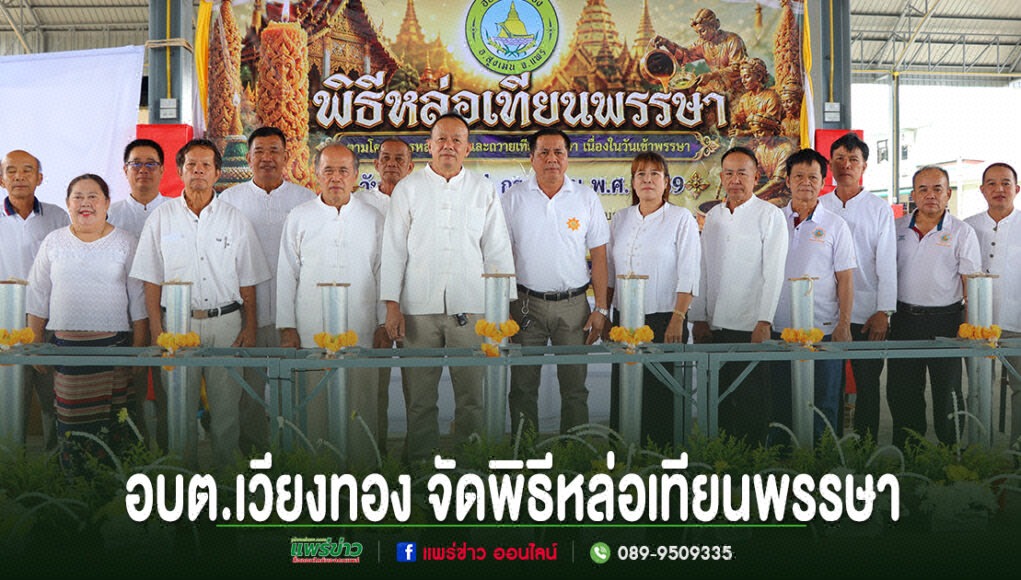 กลุ่มคนร่วมพิธีหล่อเทียนพรรษา อบต.เวียงทอง ยืนเรียงแถวหน้าป้ายพิธีและอุปกรณ์หล่อเทียน