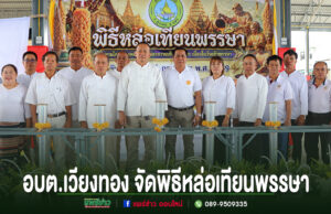 กลุ่มคนร่วมพิธีหล่อเทียนพรรษา อบต.เวียงทอง ยืนเรียงแถวหน้าป้ายพิธีและอุปกรณ์หล่อเทียน