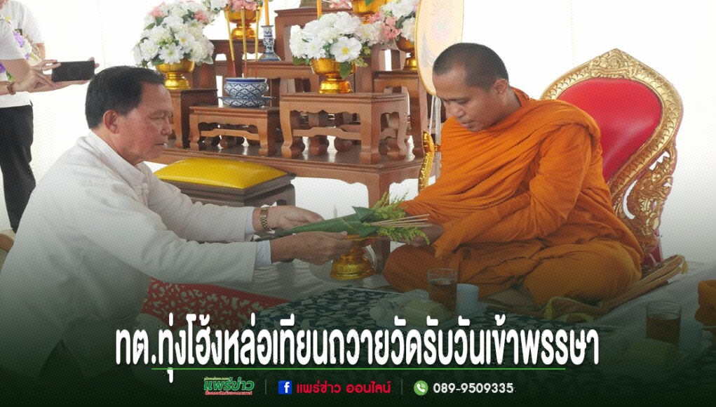 ชายในชุดขาวกำลังถวายเครื่องสักการะแด่พระภิกษุสงฆ์ ในพิธีหล่อเทียนพรรษาของ ทต.ทุ่งโฮ้ง