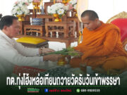 ชายในชุดขาวกำลังถวายเครื่องสักการะแด่พระภิกษุสงฆ์ ในพิธีหล่อเทียนพรรษาของ ทต.ทุ่งโฮ้ง