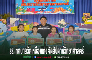 ภาพกิจกรรมสัปดาห์วิทยาศาสตร์ของโรงเรียนเทศบาลวัดเหมืองแดง มีนักเรียนและครูยืนถือป้ายรางวัลบนเวที