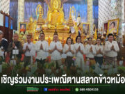 กลุ่มคนร่วมงานประเพณีตานสลากข้าวหม้อในวัด มีพระพุทธรูปสีทองขนาดใหญ่เป็นฉากหลัง
