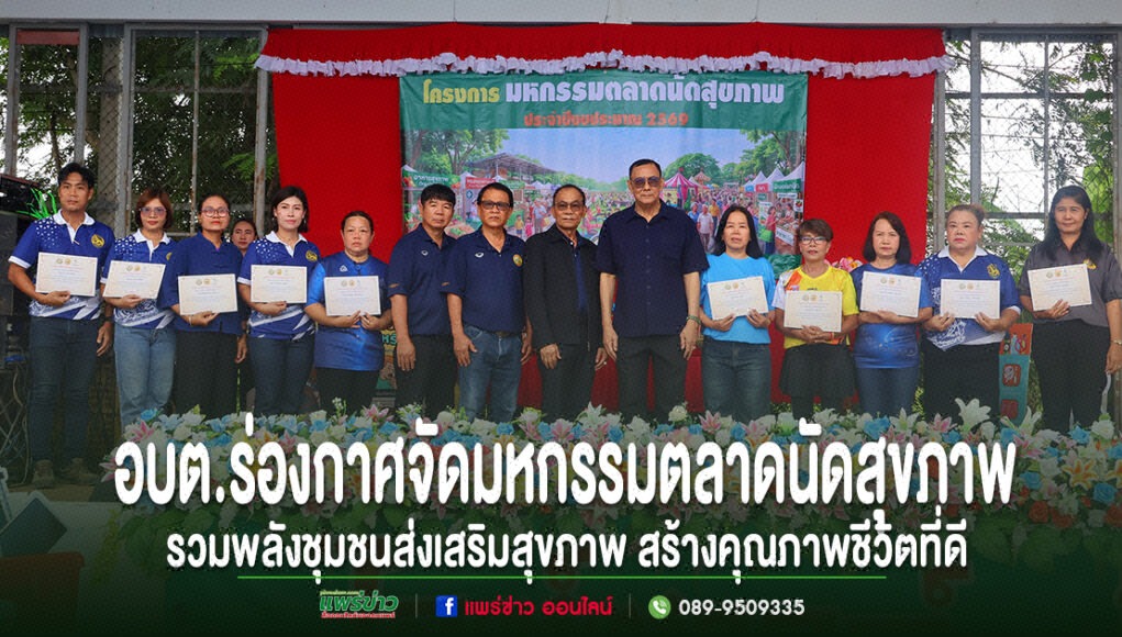 kk กลุ่มคนยืนเรียงแถวบนเวที ถือประกาศนียบัตร พร้อมข้อความภาษาไทยด้านล่างเกี่ยวกับการจัดมหกรรมตลาดนัดสุขภาพ