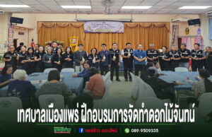 เทศบาลเมืองแพร่ เปิดกิจกรรมฝึกอบรมการจัดทำดอกไม้จันทน์ สำหรับประชาชน กลุ่มคนยืนเข้าแถวถือดอกไม้จันทน์อยู่หน้าเวที และมีผู้เข้าฝึกอบรมการทำดอกไม้จันทน์นั่งตามโต๊ะ
